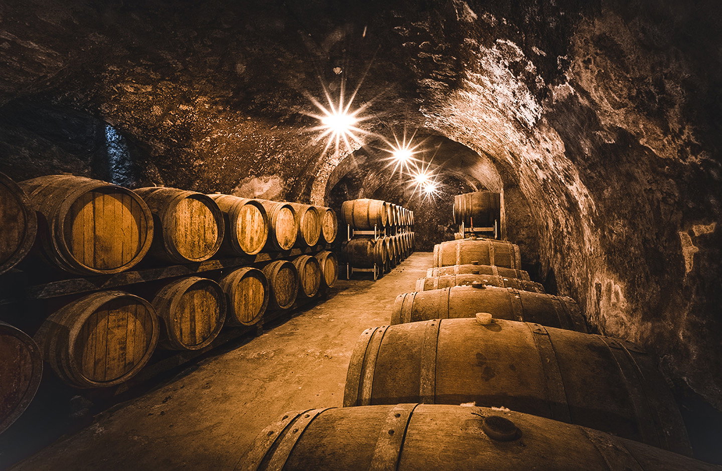 Botti in legno in una cantina storica, affinamento del vino Nosiola nelle tradizionali barriques di Trentino.