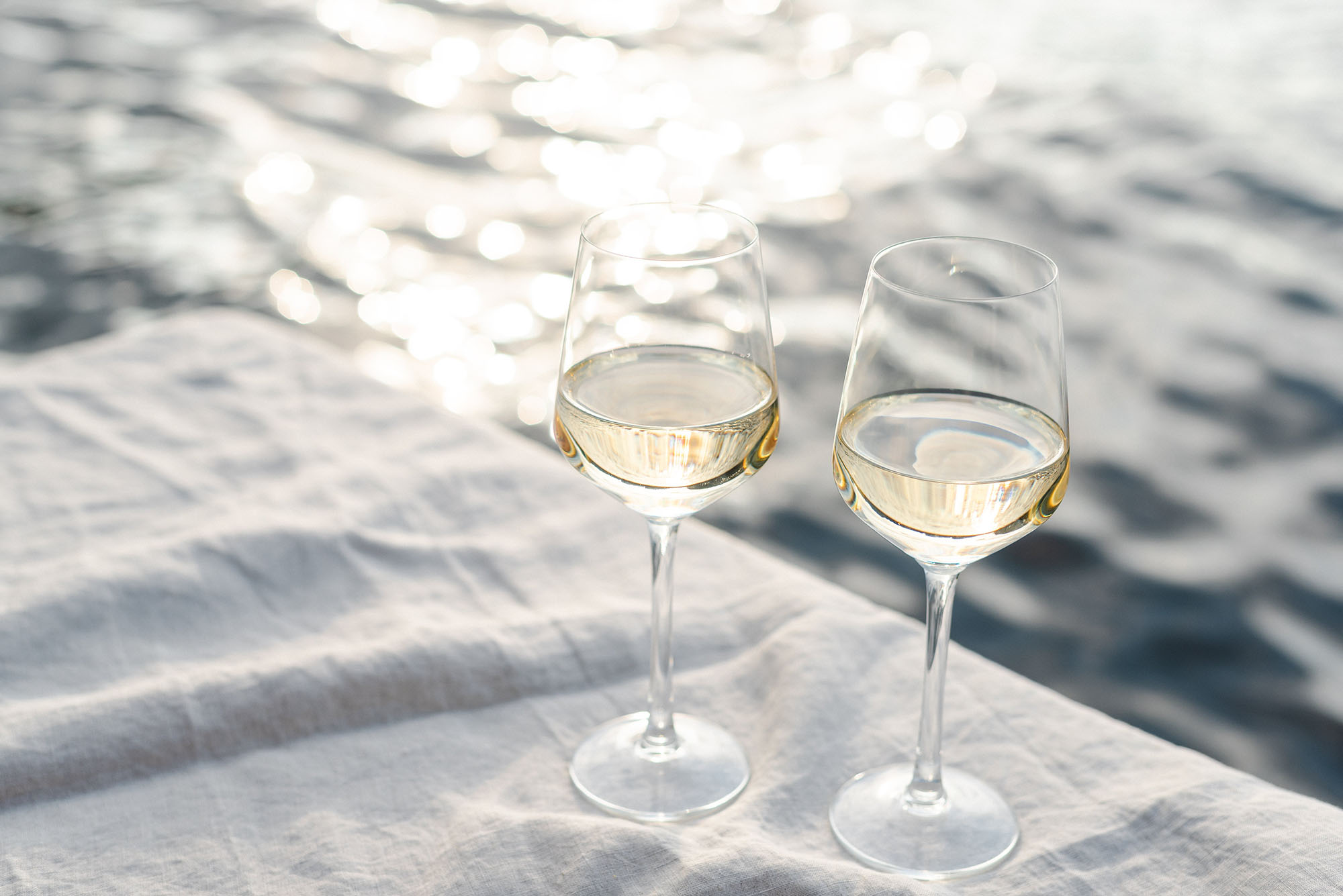 Calici di vino bianco su tavola all’aperto, atmosfera estiva