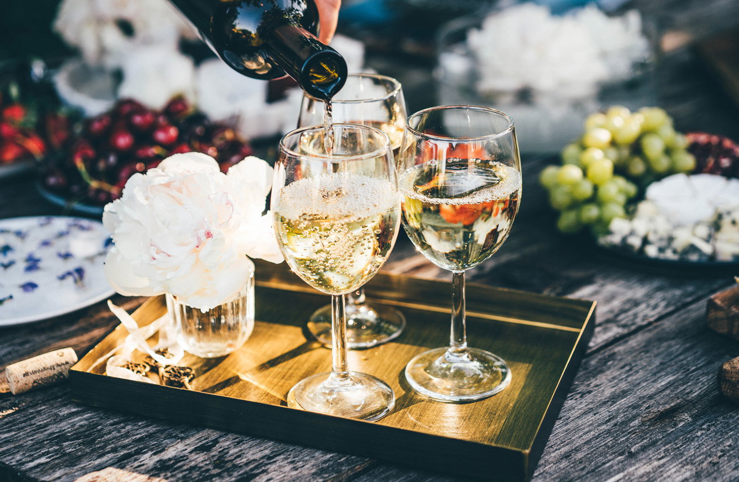 Calici di spumante con fiori e frutta su tavola elegante per matrimoni e cerimonie