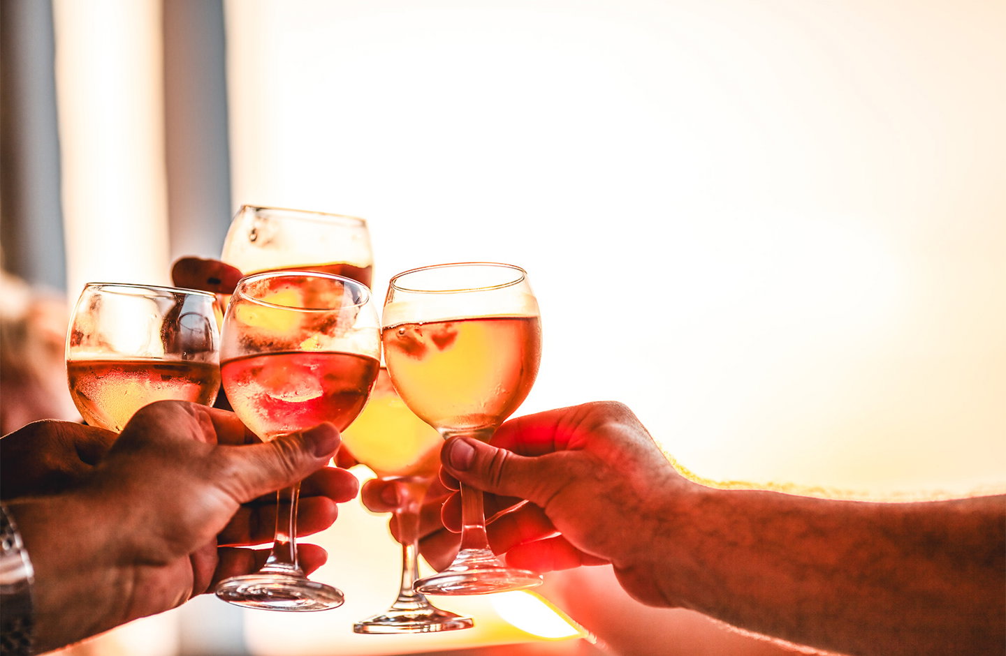 Calici di vino rosato brindano durante un aperitivo, ideale per occasioni speciali