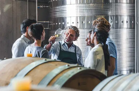 winemaker tasting wine in cellar