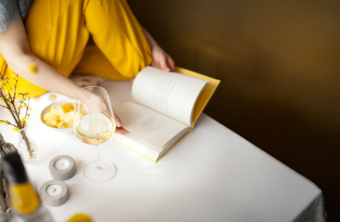 Calice di vino bianco mentre si sfoglia un libro, momento di relax con Travino